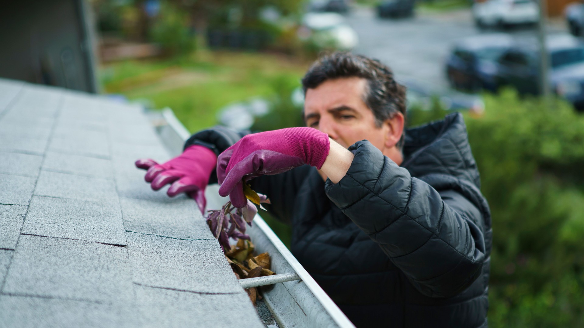 Man cleans debris from gutters
