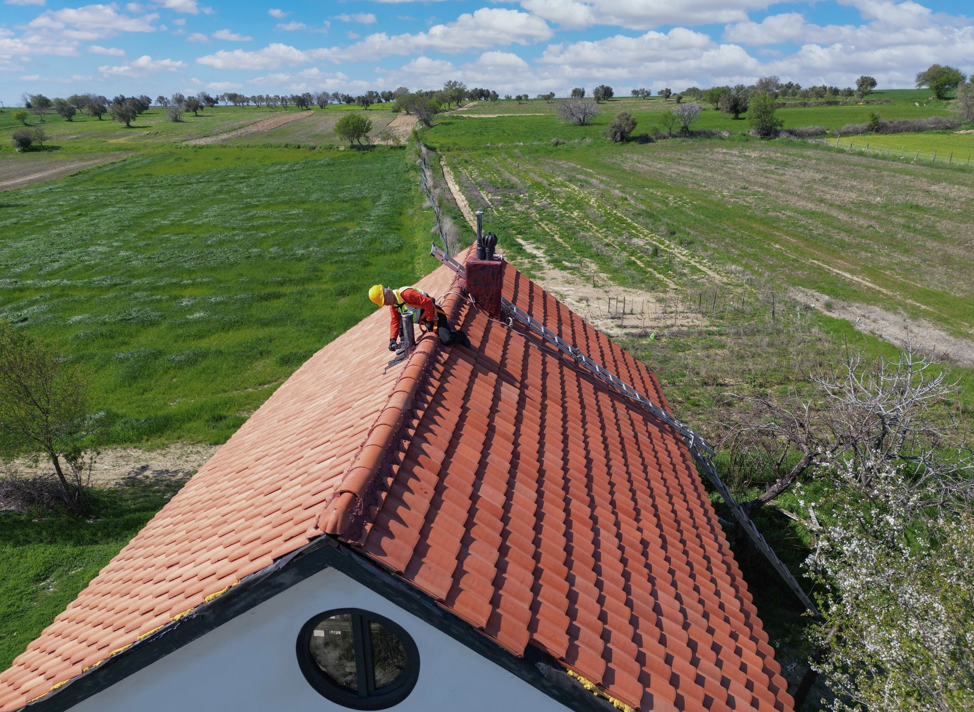 Worker doing roof repair with safety.