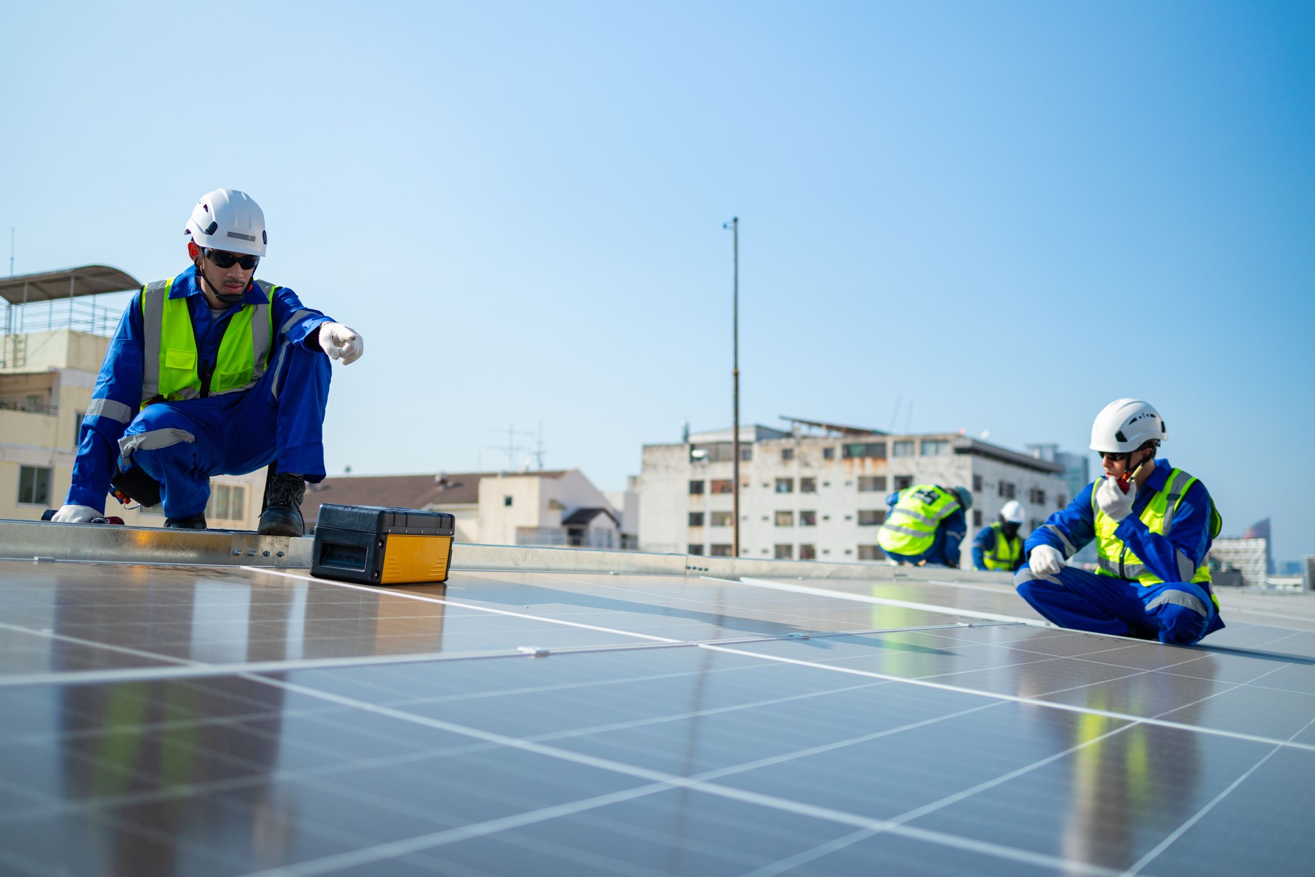 Technicians Installing Solar Panels on Roof